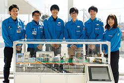 2019年度に製作した「ピストン生産工程」のミニチュアラインと製作チームのメンバー